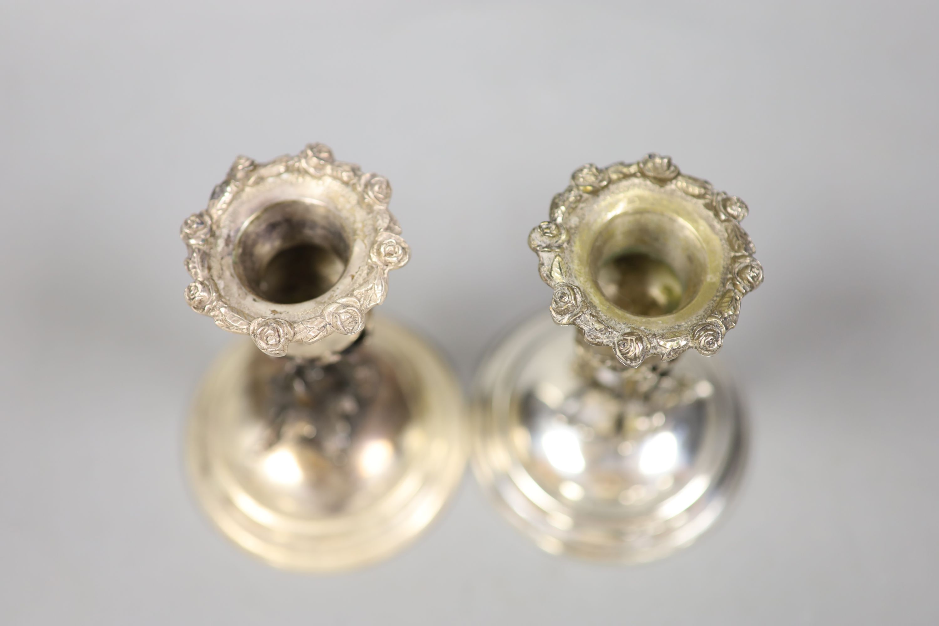 A pair of continental 830 white metal dwarf candlesticks, with foliate stems, height 12.3cm